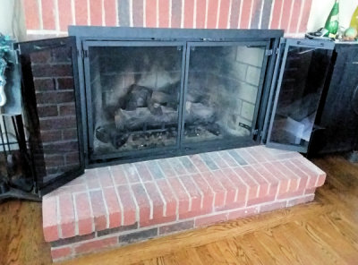 falmouth square all black finish with magnet latch bi fold doors gate mesh sprak screen installed on brick fireplace